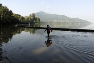 A man wades through a flooded road along the banks of Dal Lake in Srinagar